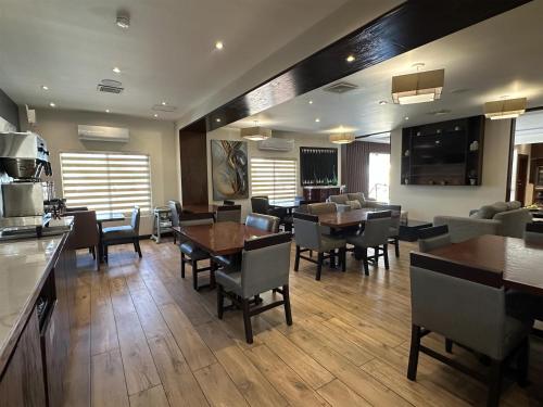 チワワにあるBest Western Plus Chihuahua Aeropuertoの部屋の中にテーブルと椅子が置かれたダイニングルーム