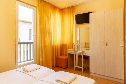 ein Schlafzimmer mit Bett, Schreibtisch und Fenster in der Unterkunft Harmony Hills Tomovi Casa 16 in Rogachevo