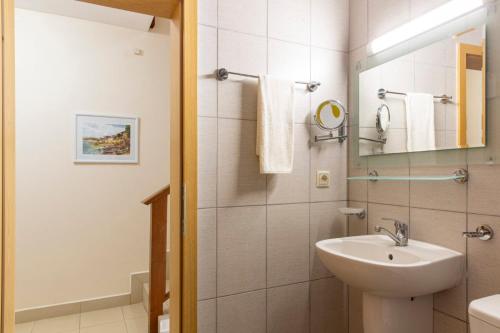 ein weißes Badezimmer mit Waschbecken und Spiegel in der Unterkunft Harmony Hills Tomovi Casa 16 in Rogachevo