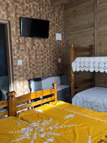 een slaapkamer met twee bedden en een flatscreen-tv bij Morada do Sol Petar in Iporanga