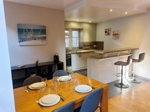 una sala da pranzo con tavolo e sedie e una cucina di Le Bullière 60m2 plein centre! a Rodez