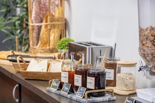 Un mostrador con frascos de comida y una tostadora. en ApartHotel Sainte-Marthe, en Aviñón