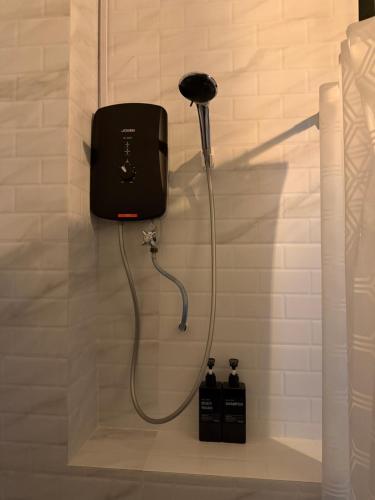 a shower in a bathroom with two soap bottles at Resilience 9 in Kota Kinabalu