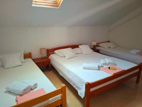 two beds in a room with two tables at Apartmani Brkan in Donja Lastva
