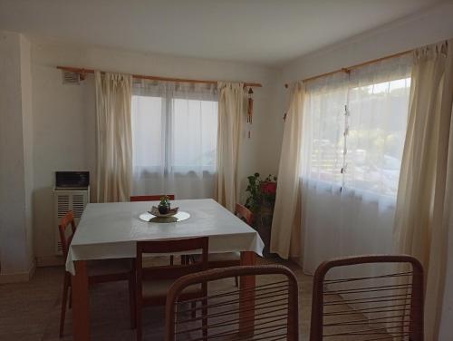 een eetkamer met een tafel en stoelen en een raam bij Abadejo in Pinamar