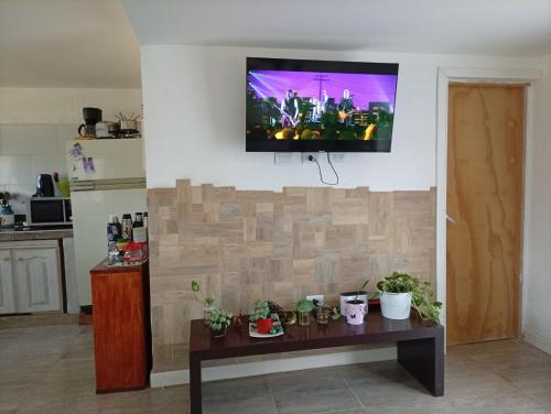 een woonkamer met een tv aan een muur bij Abadejo in Pinamar
