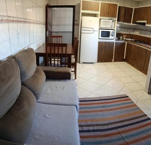 een woonkamer met een bank en een keuken bij Pensionato Marlu I in Balneário Camboriú