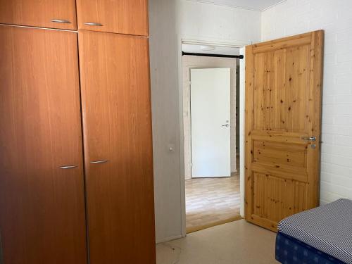 a bedroom with a wooden closet and a door at Loft house Karihaara in Kemi