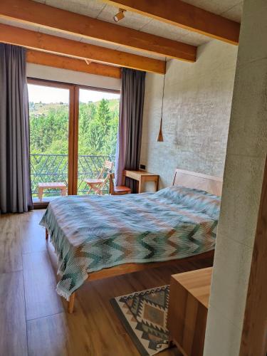 a bedroom with a bed and a large window at Тхаті in Yablunytsya