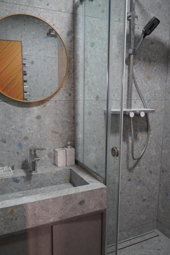 a bathroom with a shower and a sink and a mirror at Тхаті in Yablunytsya