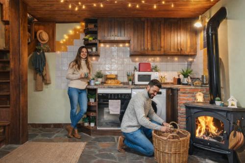 Un hombre y una mujer en una cocina con chimenea. en Montegrande, entorno mágico rodeado de montañas, en La Plaza