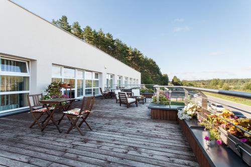 a deck with tables and chairs on a building at Mineraliniai Apartamentai in Druskininkai