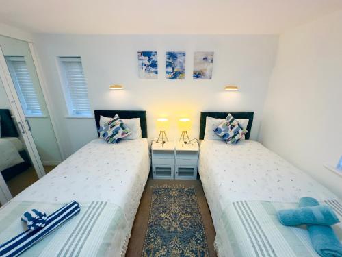 due letti uno accanto all'altro in una stanza di Entire 3-Bed Home, 5 mins to City Centre, Sleeps 6, 2 Free Parking a Colchester