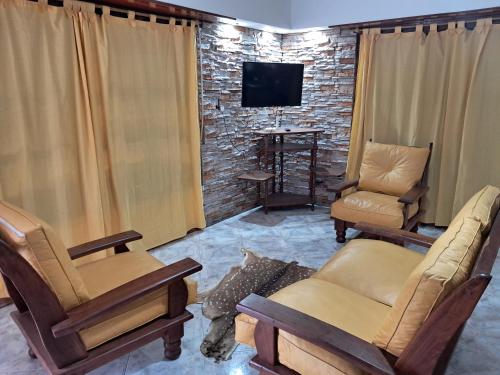 a living room with two chairs and a tv at El descanso in Mar del Plata