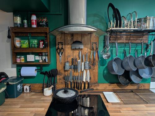 uma cozinha com muitos utensílios pendurados na parede em R4 - New Relaxing Double - City & Beach Access, WIFI, Free Parking - Self Catering em Swansea