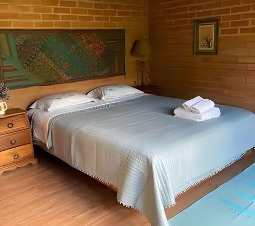 una camera da letto con un letto con due asciugamani sopra di Casa Baú’au Vista Única Conforto em Familia a São Bento do Sapucaí