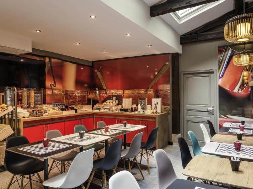 a restaurant with tables and chairs and a counter at ibis Paris Avenue de la Republique in Paris