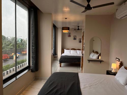 een slaapkamer met een bed en een groot raam bij BV Residency in Pondicherry