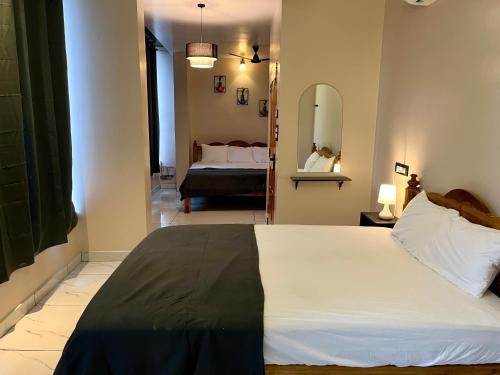 a bedroom with a large bed and a mirror at BV Residency in Pondicherry