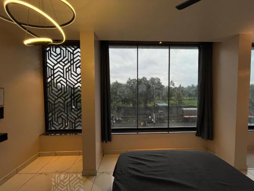 een slaapkamer met een bed en een groot raam bij BV Residency in Pondicherry