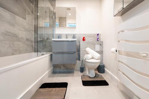 a bathroom with a toilet and a sink at LUX 2BDR Flat in Woolwich I 2 Stops to Canary Wharf & Excel I Free Parking in Woolwich