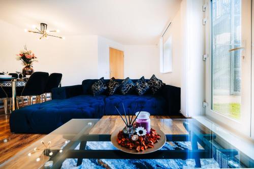 a living room with a blue couch and a table at LUX 2BDR Flat in Woolwich I 2 Stops to Canary Wharf & Excel I Free Parking in Woolwich