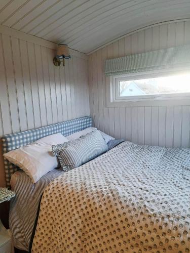 a bed in a small room with a window at Shepherds Hut Galway in Galway