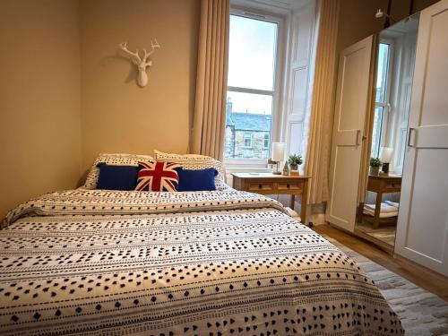 a bedroom with a bed with a british flag pillow on it at Murrayfield Spacious 2-bedroom apartment in Edinburgh