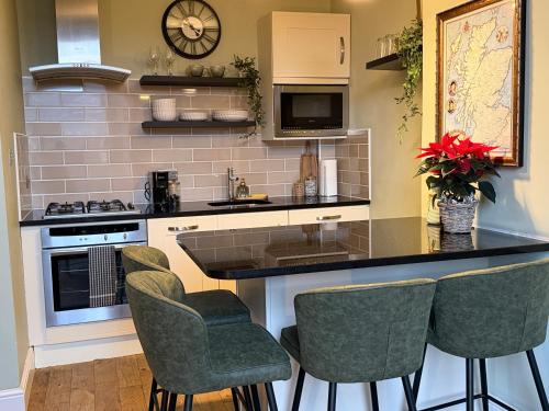 a kitchen with a counter with chairs and a sink at Murrayfield Spacious 2-bedroom apartment in Edinburgh