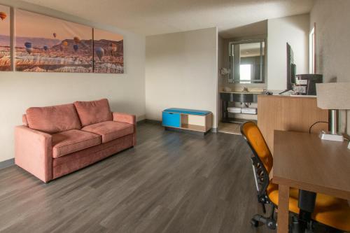 a living room with a couch and a table at Days Inn & Suites by Wyndham Albuquerque North in Albuquerque