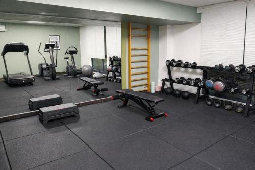 Un gimnasio con varios equipos de ejercicio en una habitación. en ApartHotel Sainte-Marthe, en Aviñón