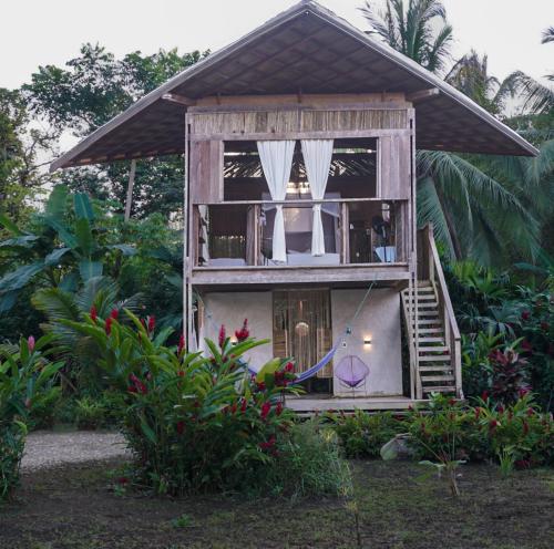 a small house with a porch and a balcony at Ecohotel Luzul in Nuquí