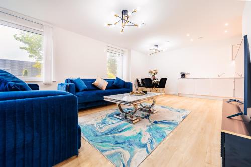a living room with a blue couch and a table at LUX 3BDR Riverside Duplex Mansionette By LCY & ExCeL I 20mins to Central London in London
