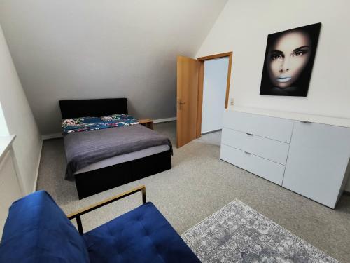 a bedroom with a bed and a dresser with a face on the wall at Lounge house in Burgau