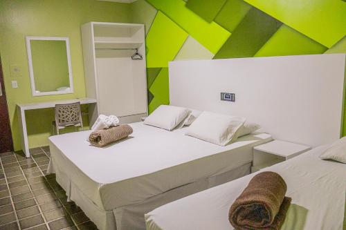 2 Betten in einem Zimmer mit Grün und Weiß in der Unterkunft Caruaru Pallace Hotel in Caruaru