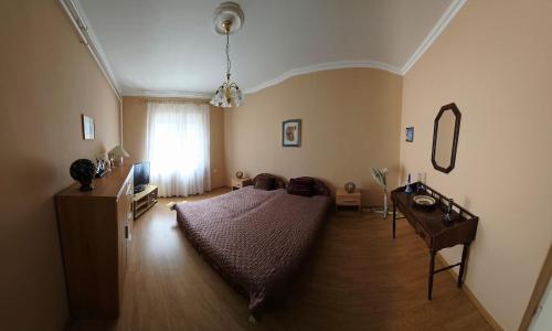 a bedroom with a bed and a table and a window at Panna Ház in Jászapáti