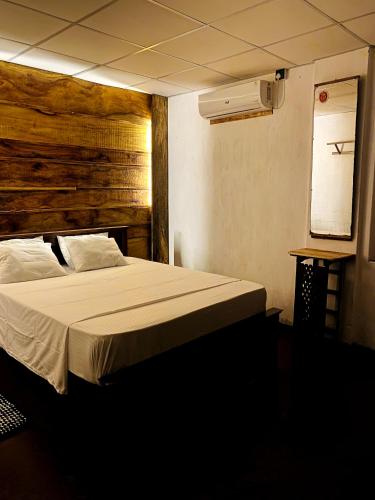 a bedroom with a large bed with a wooden headboard at Villa Meleno in Weligama