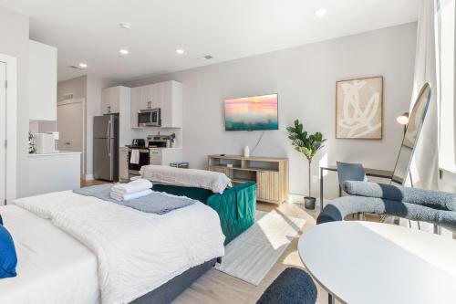 a living room with two beds and a kitchen at Lux Studio Apt - Rooftop - 5 mins to The Fillmore in Philadelphia