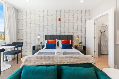 a bedroom with a large bed with blue and orange pillows at Lux Studio Apt - Rooftop - 5 mins to The Fillmore in Philadelphia