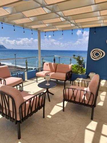 un patio avec des chaises et une vue sur l'océan dans l'établissement Mediterrâneo Madeira, à São Vicente