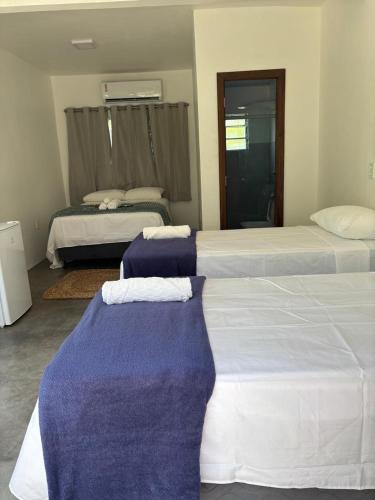 a bedroom with two beds with blue and white sheets at VILA DO RIO in Santo Amaro