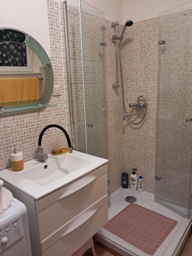 Un baño blanco con lavabo y ducha. en Kawalerka nad Zatoką, en Gdynia