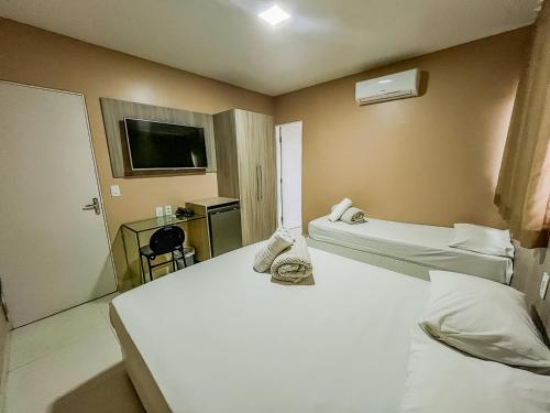 カルアルにあるHotel Itaparicaのベッド2台とテレビがあるホテルの部屋