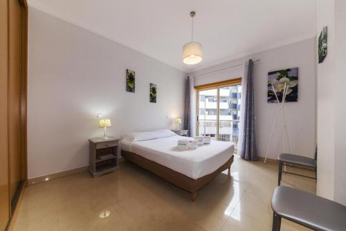 een slaapkamer met een wit bed en een raam bij C05 - Convento Apartment in Lagos