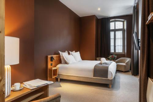 Un dormitorio con una cama, una silla y un escritorio. en Maison Soyeuse, en Briançon