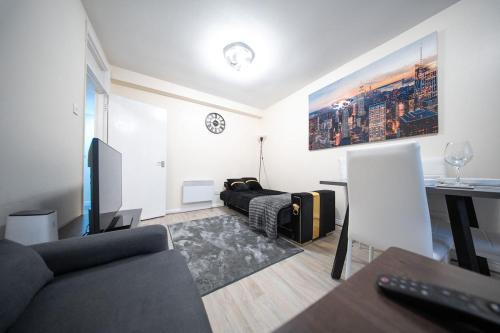 a living room with a couch and a television at Cosy 2 BR Apt, DLR, London City Airport & ExCeL in London