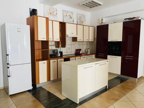 eine Küche mit weißen Schränken und einem weißen Kühlschrank in der Unterkunft Apartament Modern & Spatios - La 2 minute de Mare in Mamaia Nord – Năvodari
