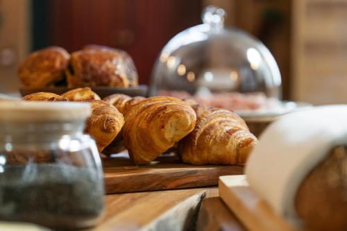 Un montón de croissants en una tabla de cortar de madera en Maison Soyeuse, en Briançon