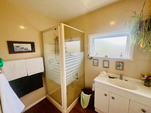 ein Badezimmer mit Dusche und Waschbecken in der Unterkunft The Sweet Spot Family Home Centrally Located Motueka in Motueka