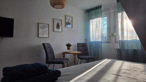 una camera da letto con un letto, due sedie e un tavolo di MaxMir - Ortlohn Iserlohn a Iserlohn